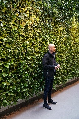 Ulrich foran plantevæg hos Aabenraa hospital Mand foran en væg med planter