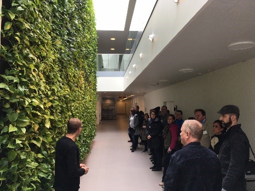 Ekskursion Training Day En gruppe mennesker på gang kigger på en væg med planter